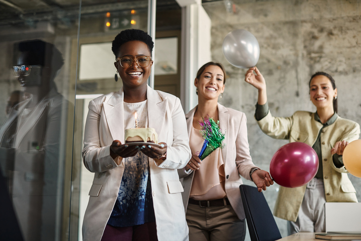 Happy African American businesswoman and her female colleagues having fun on office party.